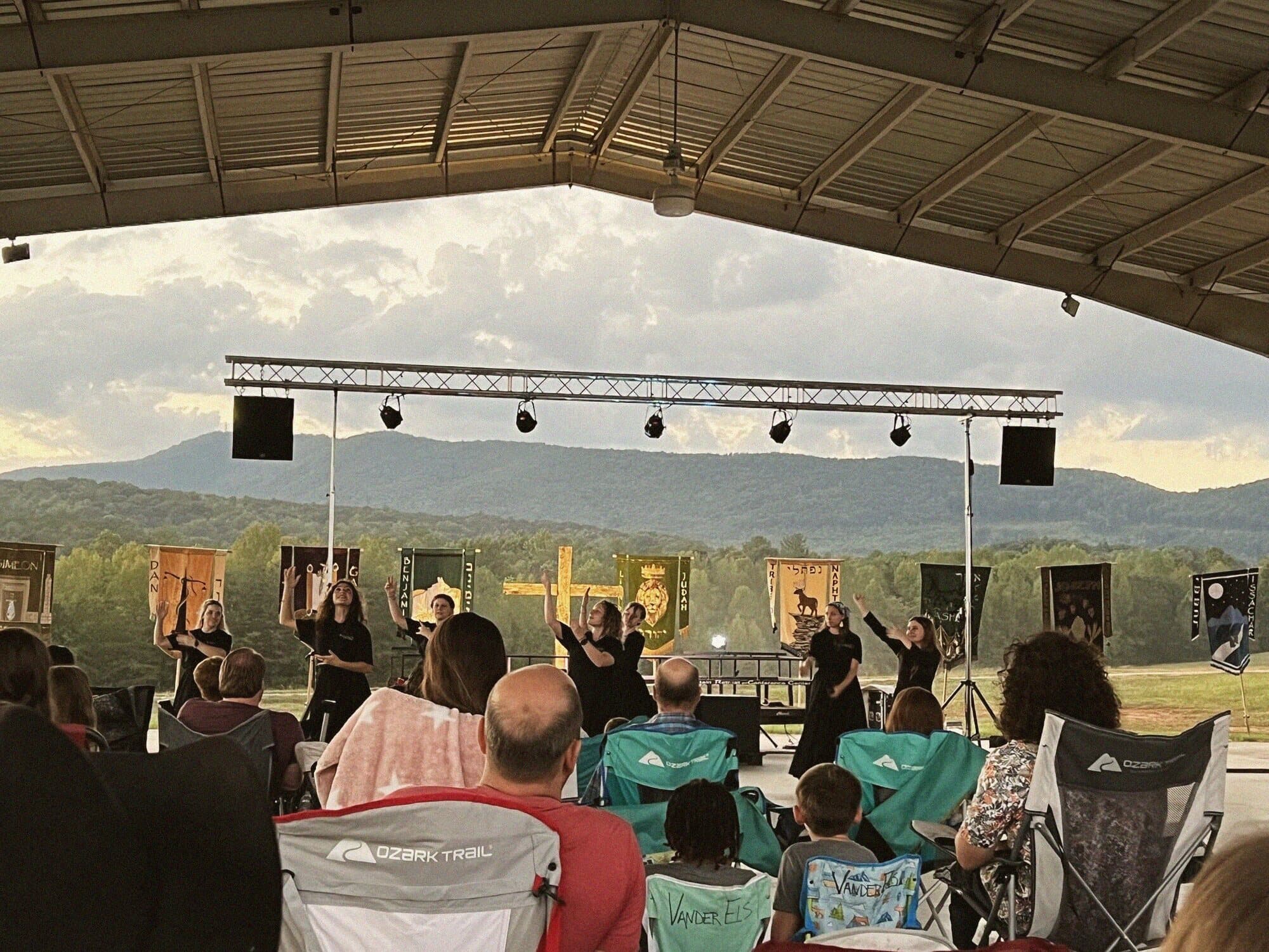 Worship at a Founded in Truth feast gathering, mountains behind the stage