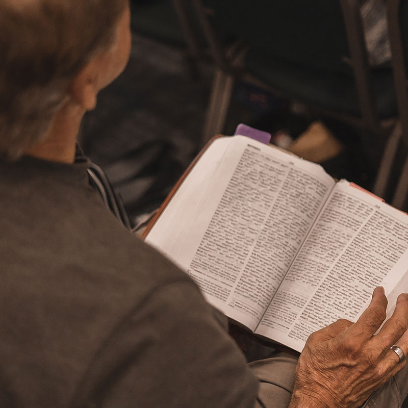 man reading his bible in church