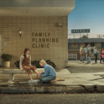 A pro-life protestor washing the feet of a young woman as a women's clinic